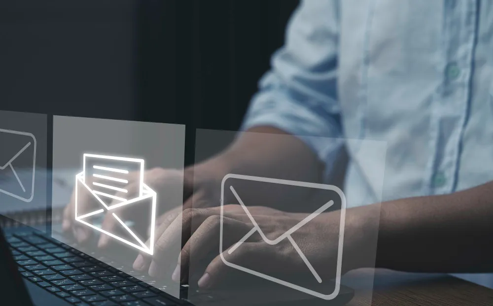 Profissional digita em laptop representando envio de e-mail corporativo para comunicação empresarial eficiente.
